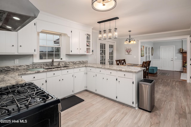 kitchen featuring sink, custom exhaust hood, decorative light fixtures, kitchen peninsula, and white cabinets