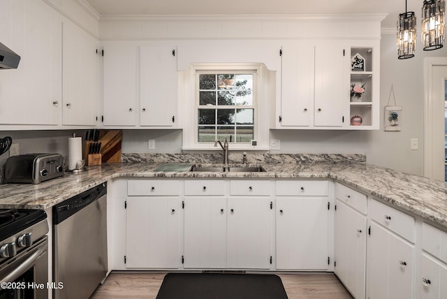 kitchen with appliances with stainless steel finishes, pendant lighting, white cabinetry, sink, and crown molding