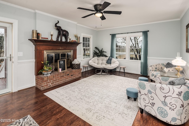 living room featuring dark hardwood / wood-style flooring, a fireplace, ornamental molding, and ceiling fan