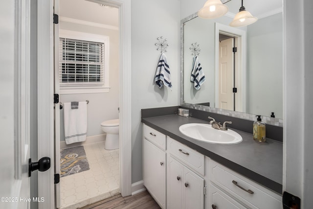 bathroom featuring vanity, crown molding, and toilet