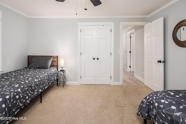 bedroom with crown molding, carpet floors, ceiling fan, and a closet