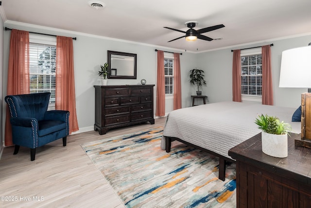 bedroom with ornamental molding, ceiling fan, and light hardwood / wood-style flooring