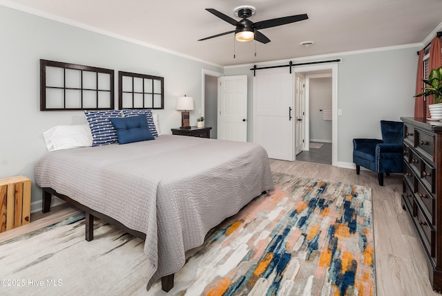 bedroom with ornamental molding, a barn door, ceiling fan, and light wood-type flooring