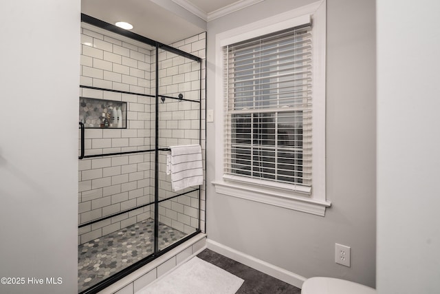 bathroom with crown molding and a shower with shower door