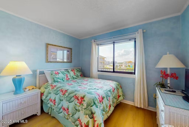 bedroom featuring crown molding and light hardwood / wood-style floors