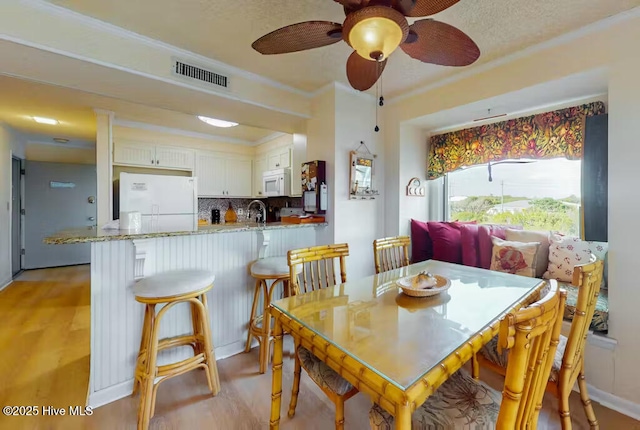 dining area with sink and light hardwood / wood-style flooring