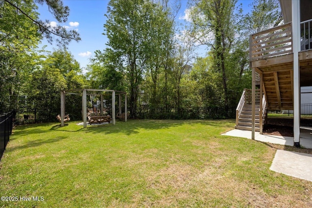 view of yard featuring a fenced backyard, a wooden deck, and stairs