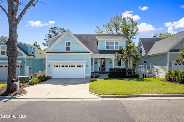 craftsman-style home featuring a front lawn, central air condition unit, driveway, covered porch, and an attached garage