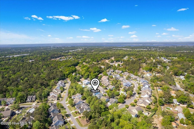 drone / aerial view featuring a residential view and a forest view