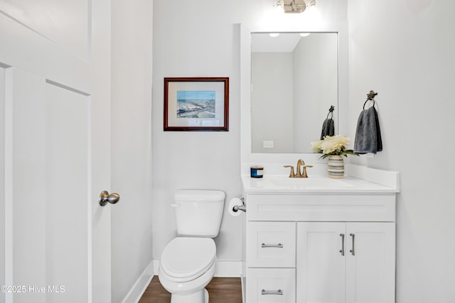 bathroom with baseboards, vanity, and toilet