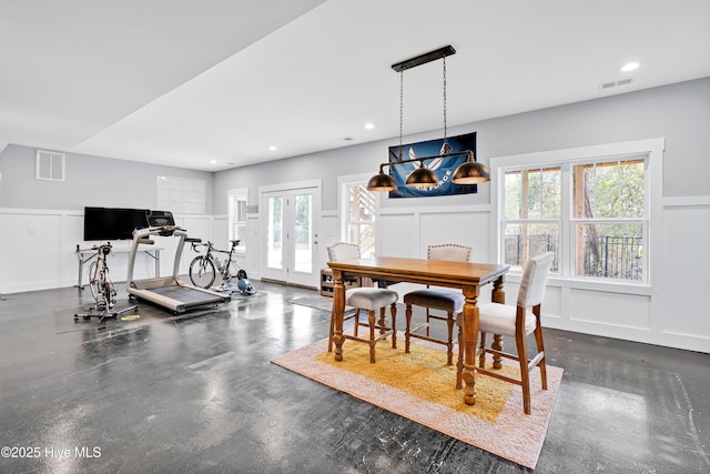 exercise area with wainscoting, french doors, visible vents, and a decorative wall