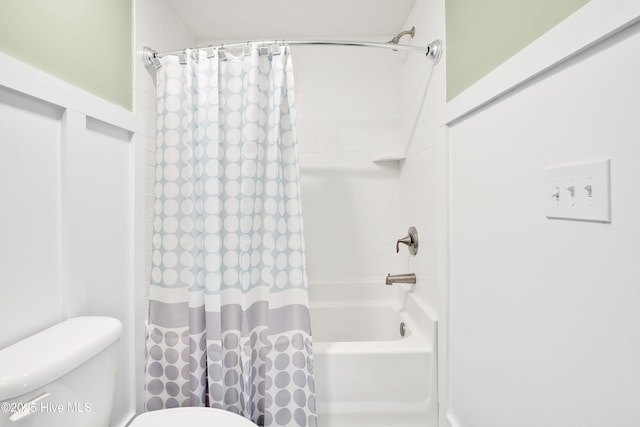 bathroom featuring shower / tub combo with curtain and toilet