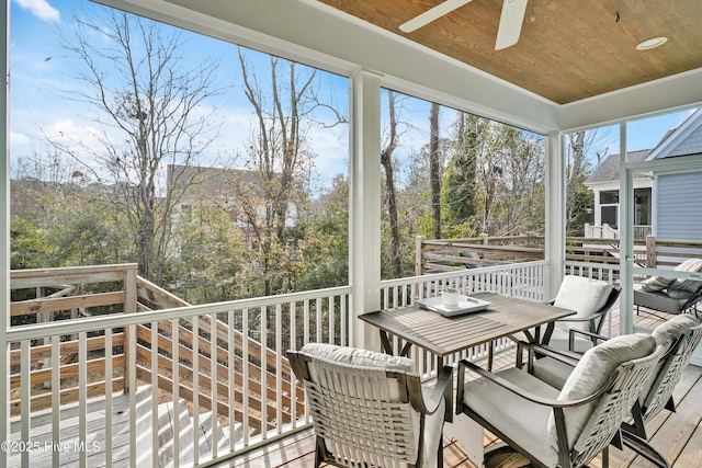 wooden terrace featuring outdoor dining space and a ceiling fan