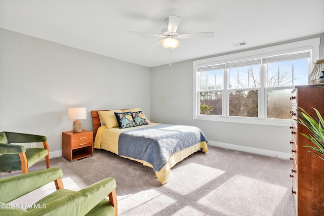 carpeted bedroom with baseboards, a ceiling fan, and visible vents
