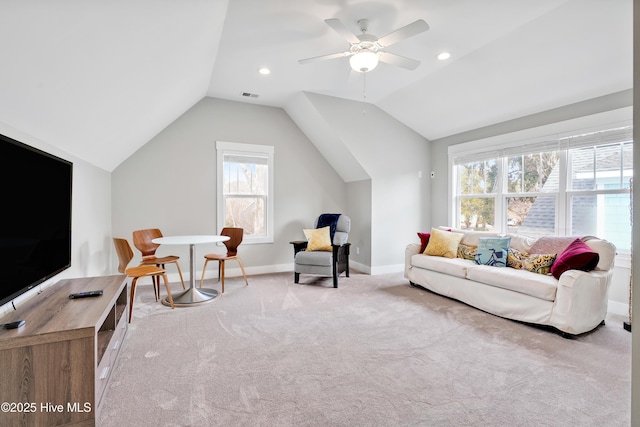 carpeted living room with baseboards, vaulted ceiling, visible vents, and ceiling fan