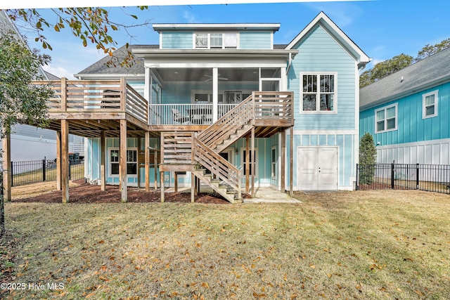 back of property featuring a deck, a fenced backyard, a yard, a sunroom, and stairs