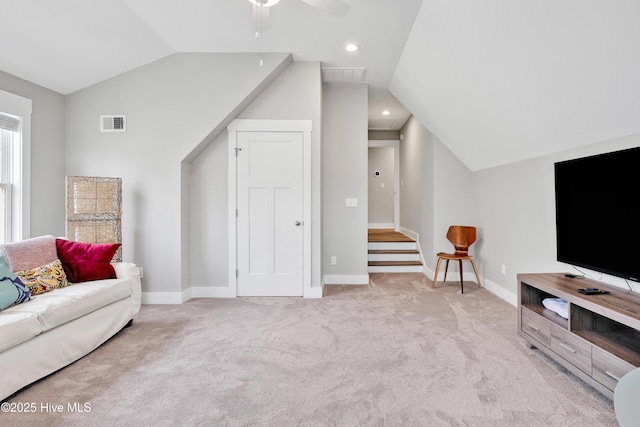 living room with baseboards, visible vents, light colored carpet, lofted ceiling, and ceiling fan