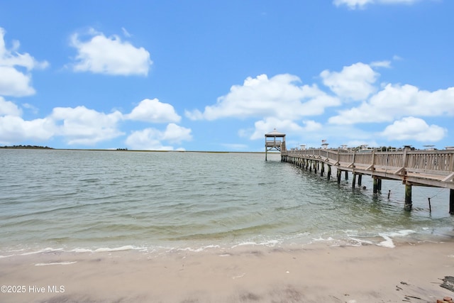 view of dock with a water view and a view of the beach