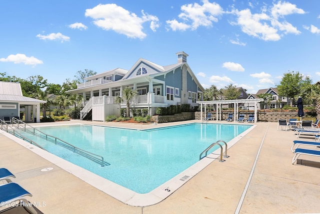 pool with a patio area and a pergola