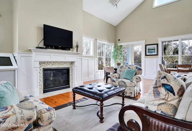 living room with a decorative wall, a fireplace, and light wood finished floors