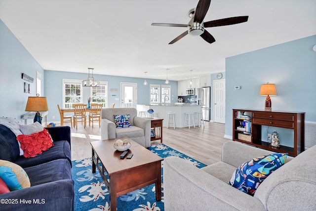 living room with ceiling fan and light wood-type flooring