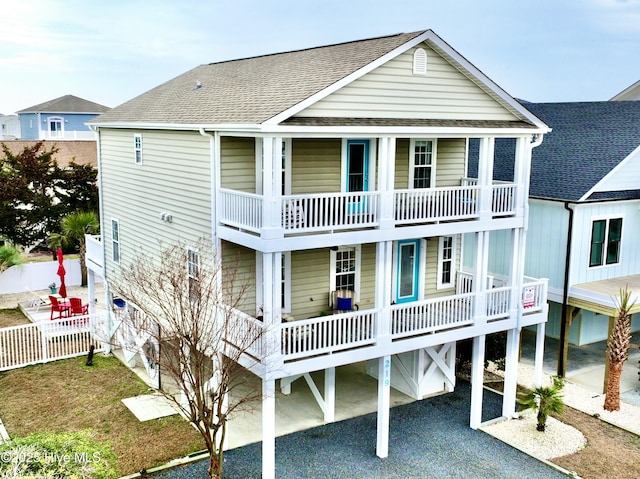 rear view of property featuring a porch and a balcony