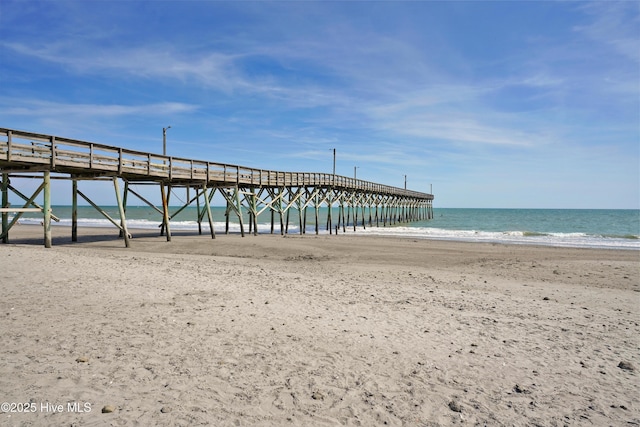 dock area featuring a water view and a beach view