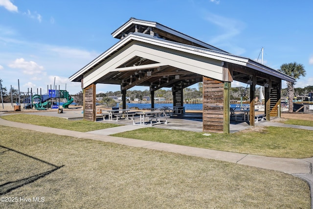 surrounding community featuring a playground, a gazebo, and a yard