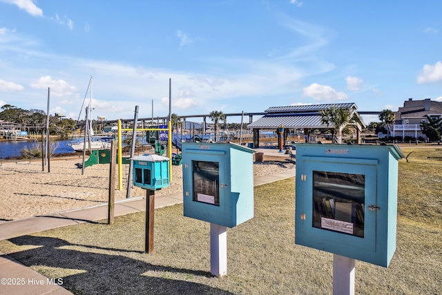 view of community featuring a playground, a gazebo, and a water view