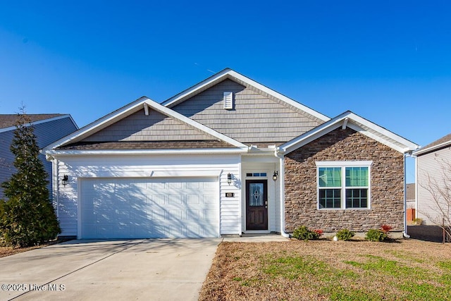 view of front of property featuring a garage, stone siding, and driveway