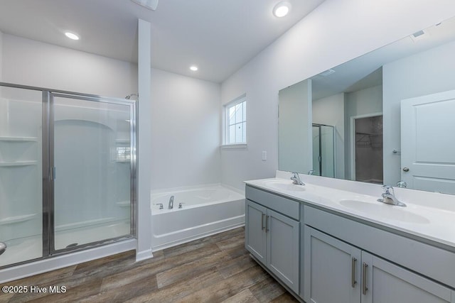 bathroom featuring vanity, separate shower and tub, and hardwood / wood-style floors