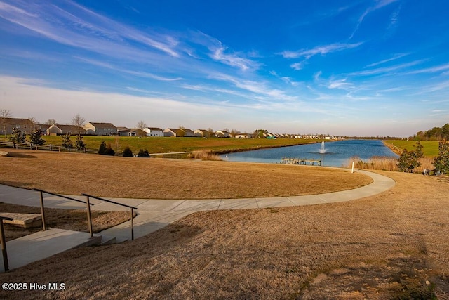 view of home's community featuring a lawn and a water view