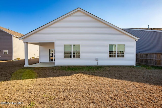 back of house featuring a lawn and a patio area