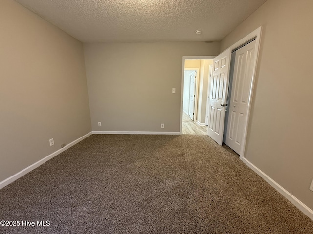 unfurnished room with carpet floors and a textured ceiling