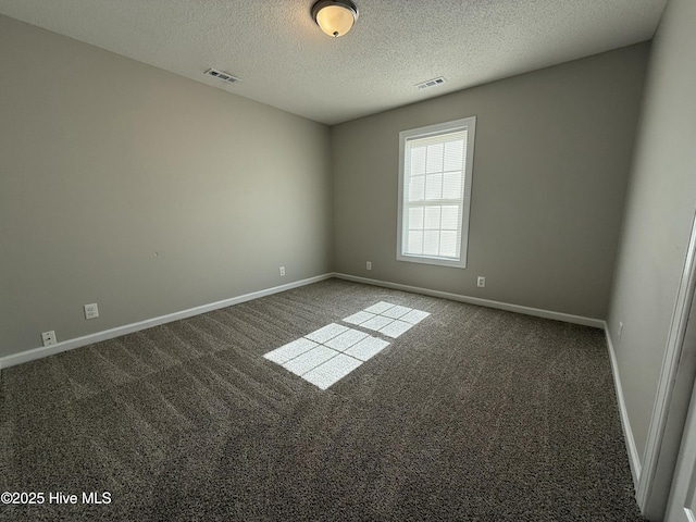 carpeted empty room featuring a textured ceiling