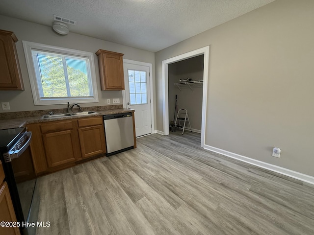 kitchen featuring sink, dishwasher, black electric range, a textured ceiling, and light wood-type flooring