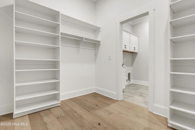 walk in closet with hardwood / wood-style floors