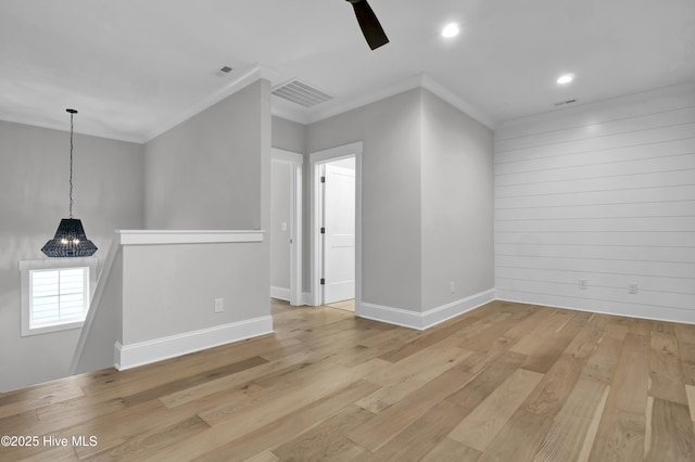 spare room featuring ornamental molding and light wood-type flooring