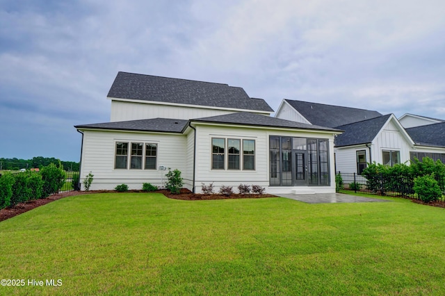 back of house with a patio area and a lawn