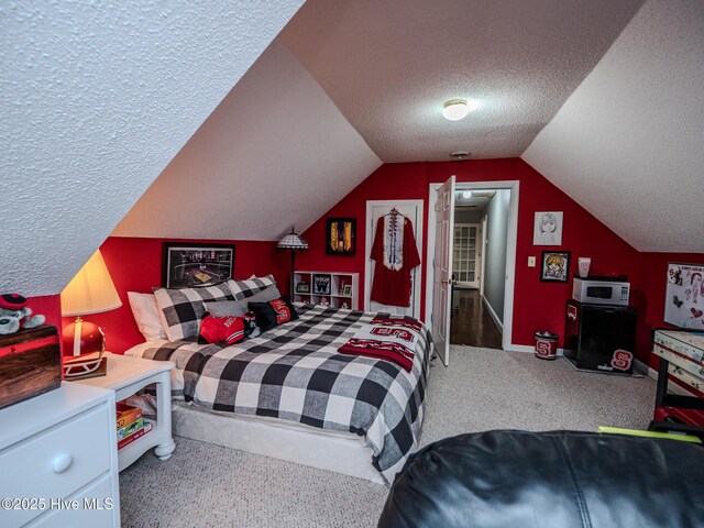 carpeted bedroom with vaulted ceiling and a textured ceiling