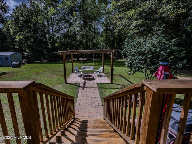 deck with an outdoor fire pit and a lawn