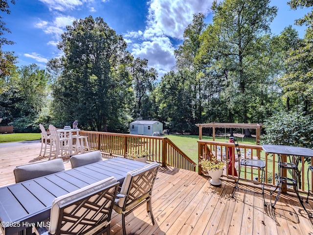 wooden terrace with a storage shed and a yard