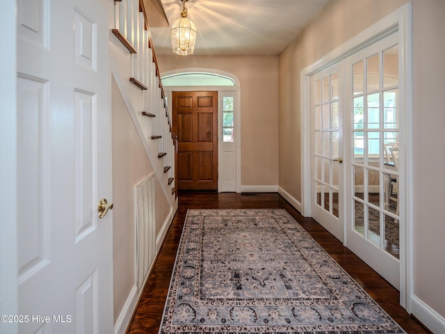 entryway featuring dark hardwood / wood-style flooring and a notable chandelier