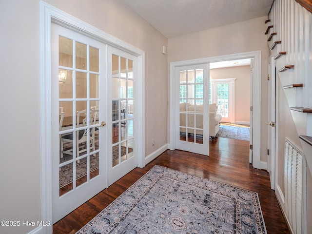 doorway to outside featuring dark wood-type flooring, a textured ceiling, and french doors