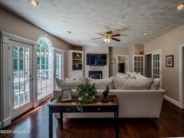 living room with dark hardwood / wood-style flooring, ceiling fan, french doors, and a textured ceiling