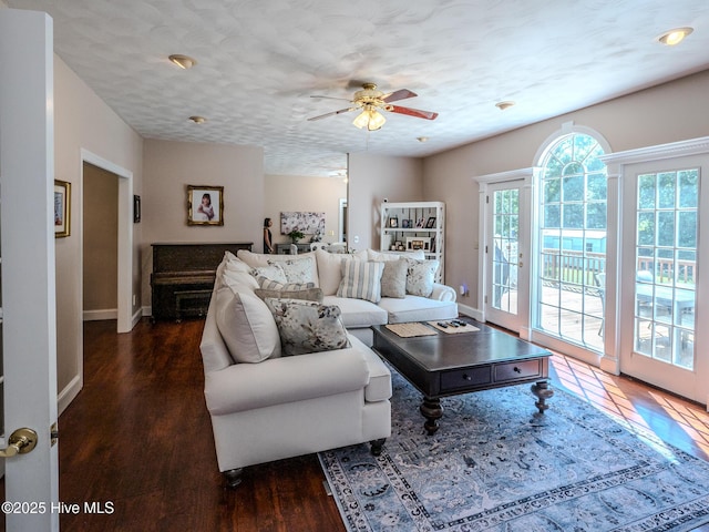 living room featuring a textured ceiling, dark hardwood / wood-style floors, and ceiling fan