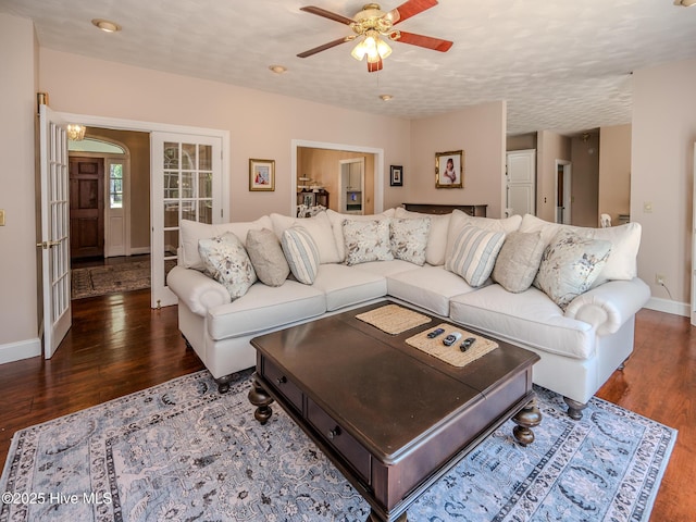 living room featuring ceiling fan and dark hardwood / wood-style flooring