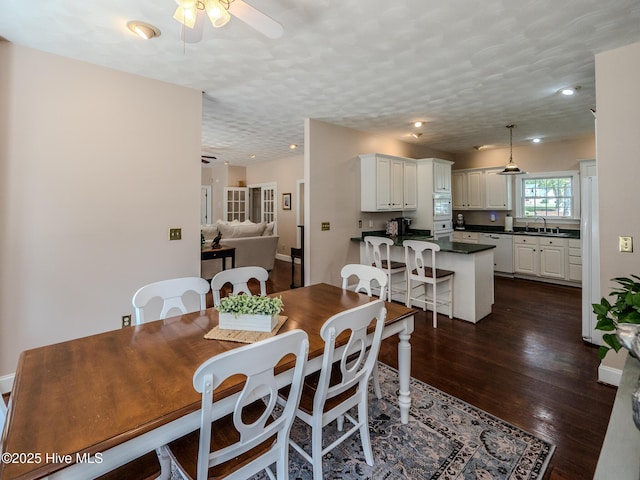 dining space with ceiling fan, dark hardwood / wood-style flooring, sink, and a textured ceiling