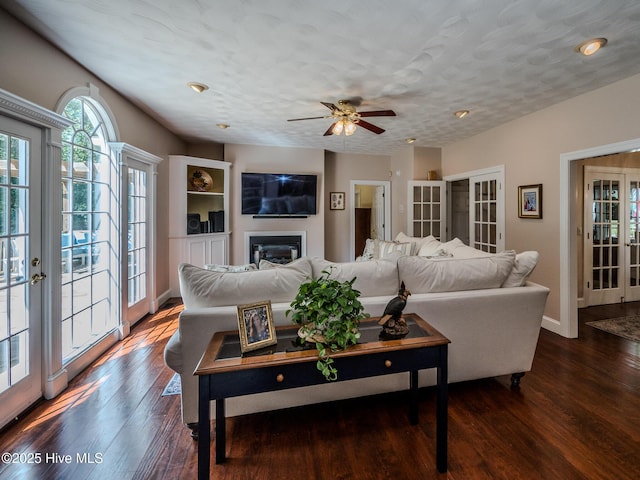 living room with french doors, dark hardwood / wood-style floors, and a textured ceiling