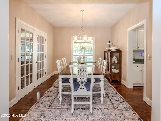 dining room featuring a notable chandelier, dark hardwood / wood-style flooring, and french doors